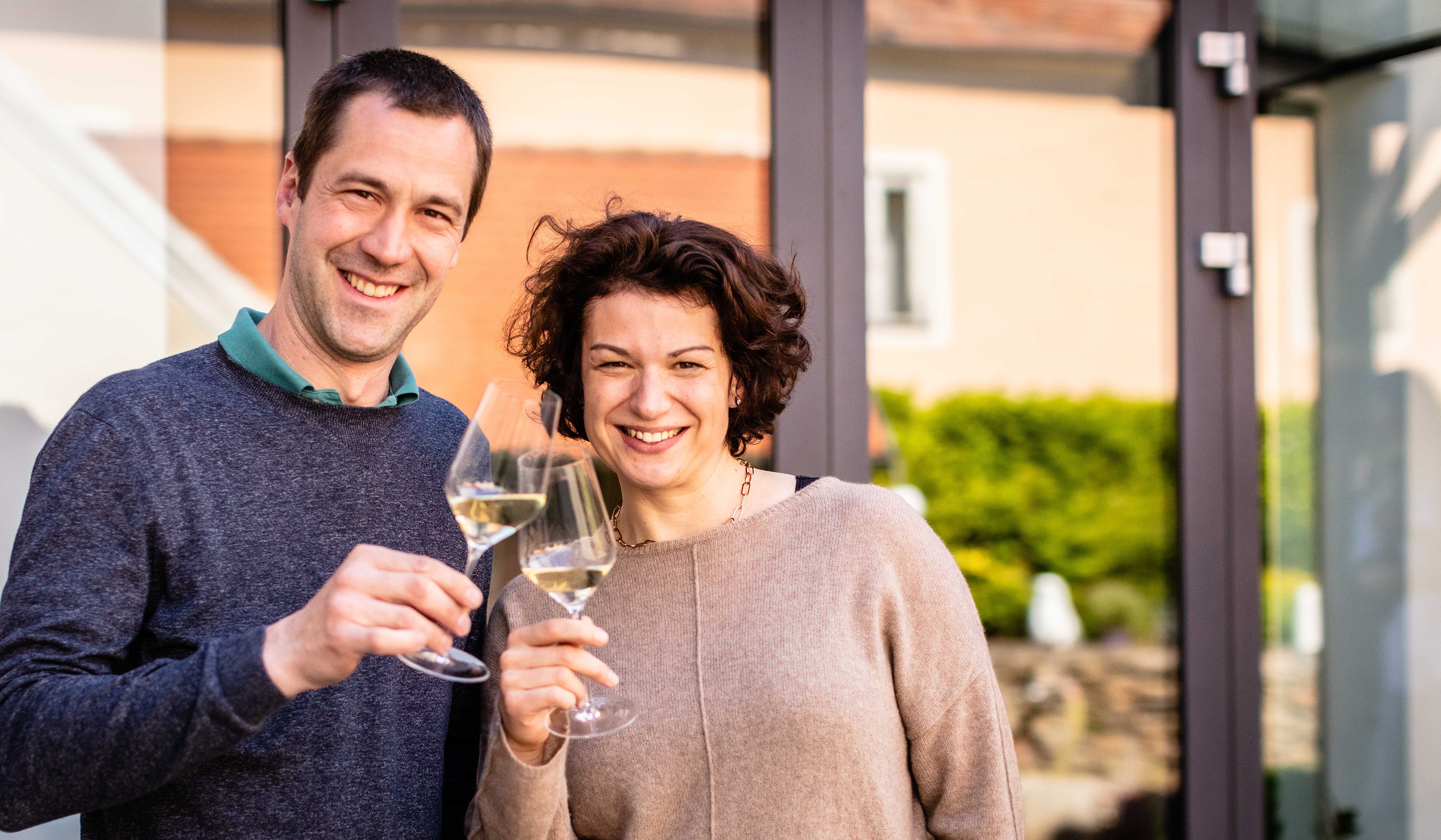 Leo Alzinger mit seiner Frau auf der Terrasse und stoßen mit einem Glas Wein an