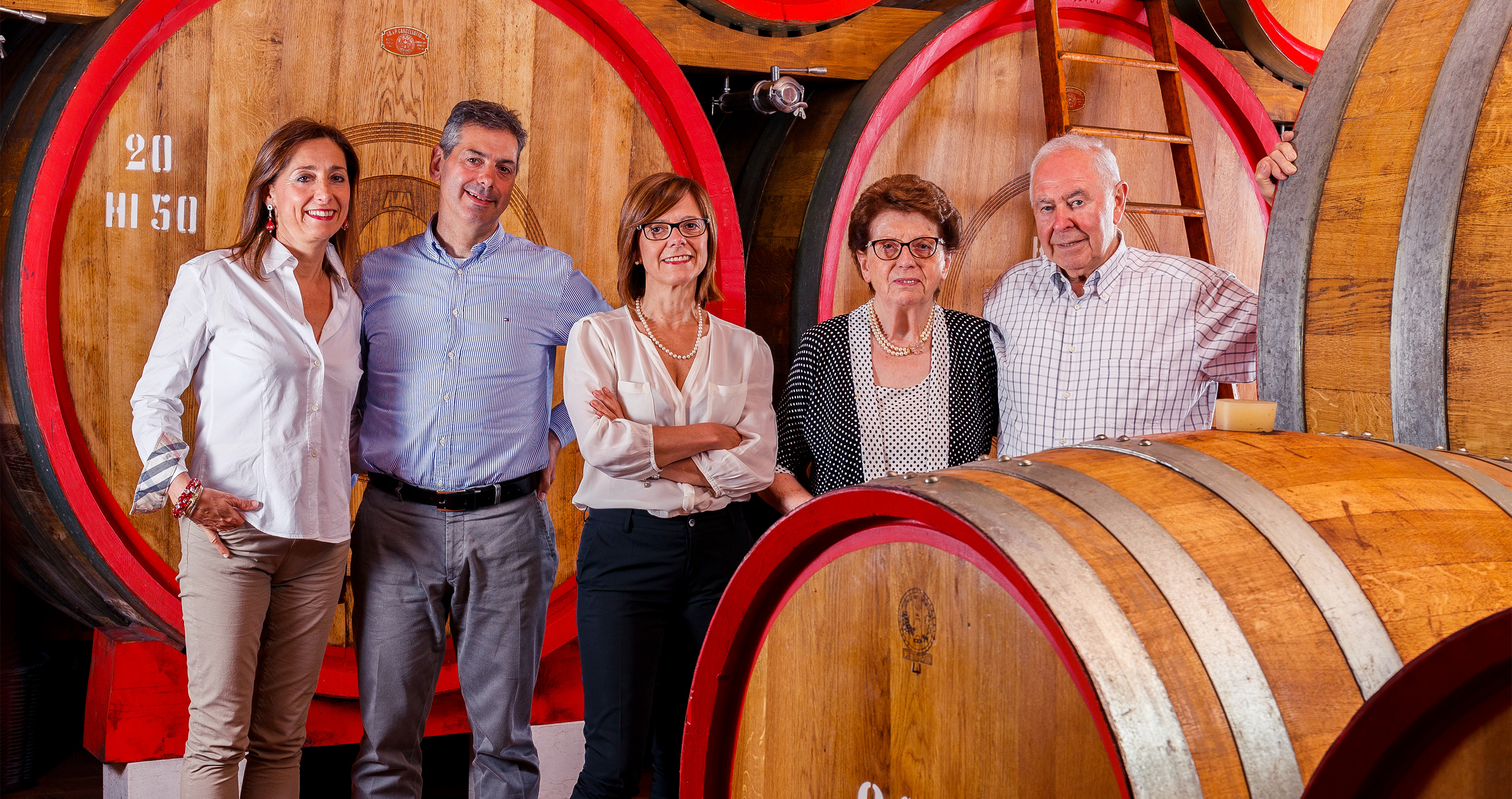 Familie Tedeschi steht zwischen großen Weinfässern