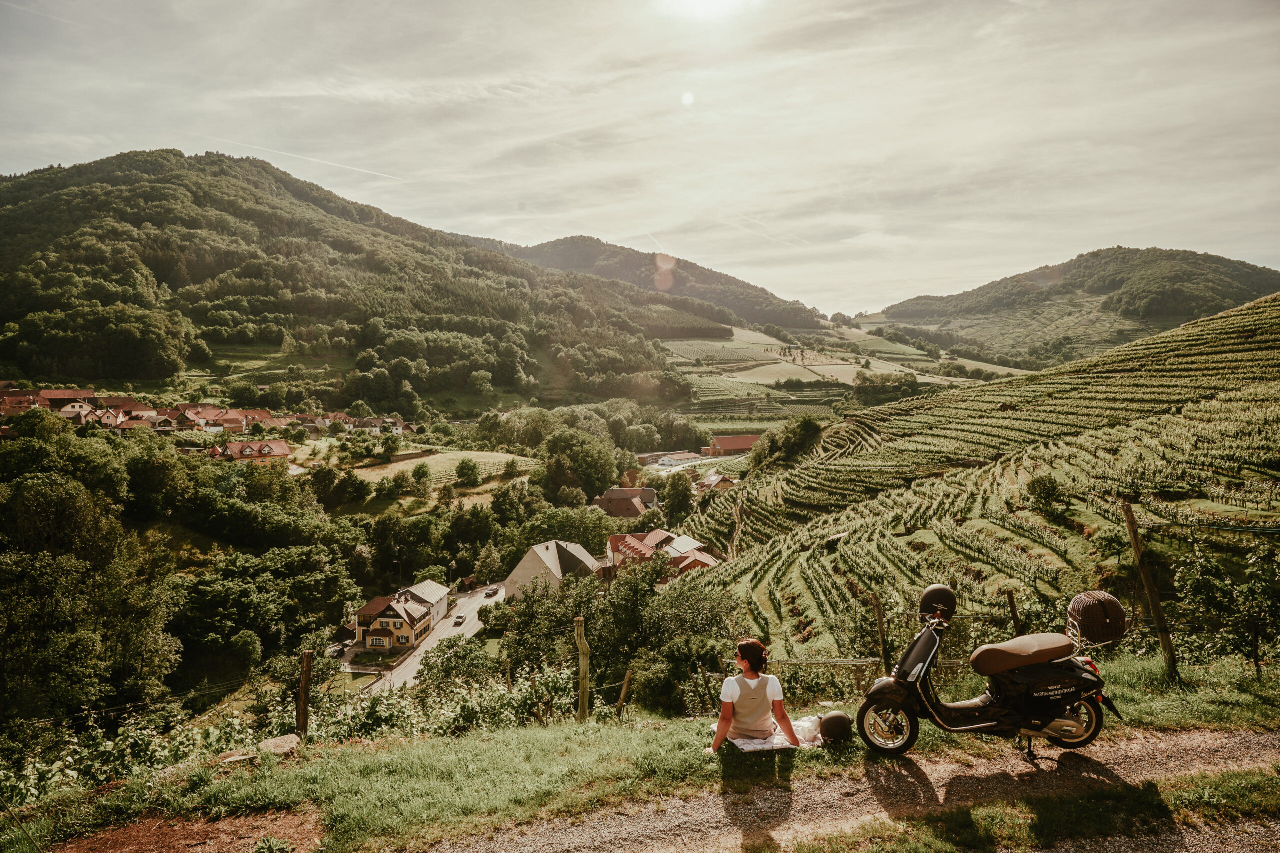 Ansicht der Riede Spitzer Graben von Oben mit einer Vespafahrerin, die soeben die herrliche Aussicht genießt, von Oben