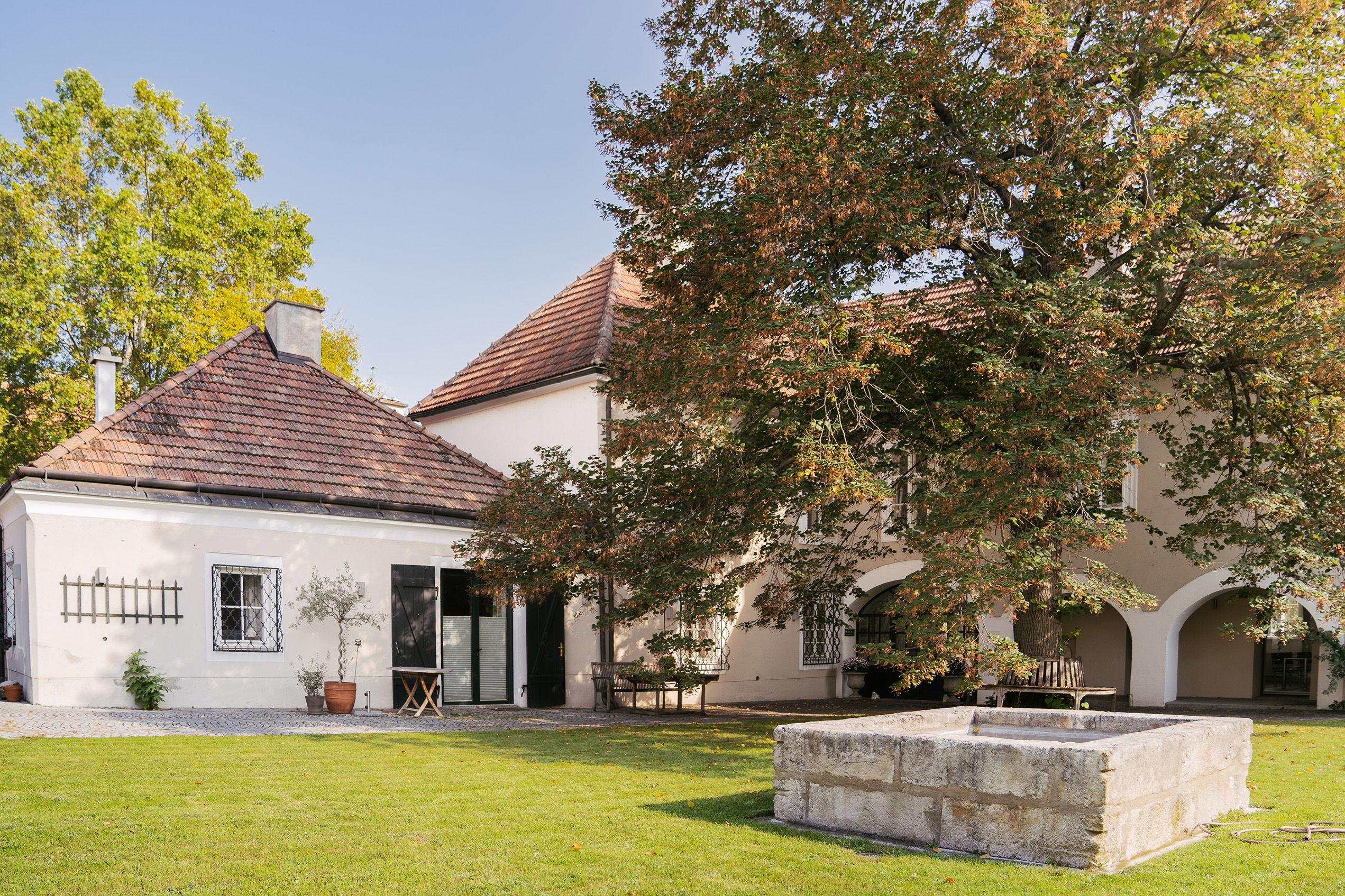 Hauptgebäude Weingut Salomon Undhof - schöner Hof mit Grünfläche und Brunnen im Vordergrund